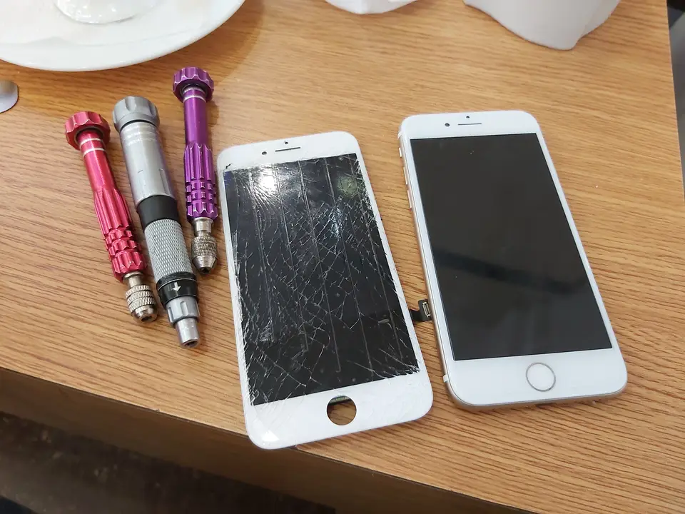Pantalla quebrada de iPhone junto a su reemplazo en el taller PuertoApple
